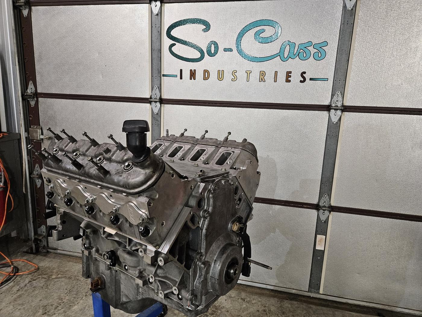 Assembled engine on a stand in front of the So-Cass garage door